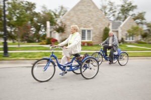 Man and woman riding blue bicycles through Covenant neighborhoods