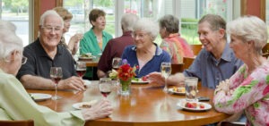 Group of friends sitting at circular table enjoying happy hour together