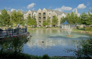 Pond and fountain with duck swimming in front of Covenant Village building