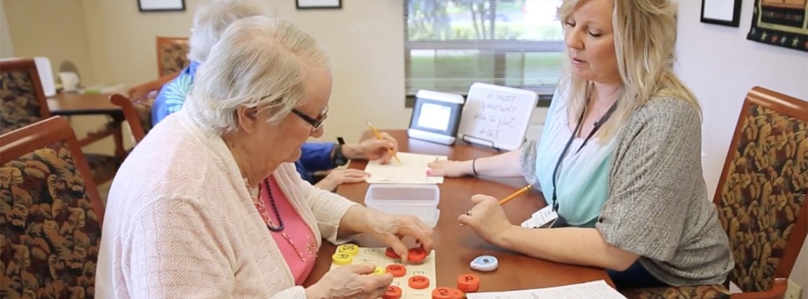 Woman assisting two older residents with memory activity