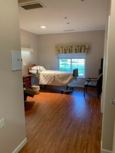 Empty bedroom with hospital bed next to window