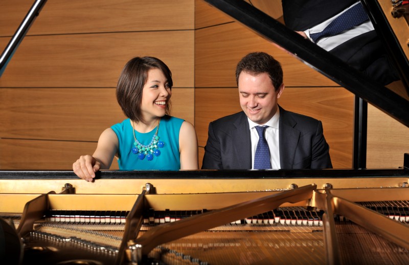 Man and woman sitting at a piano playing together