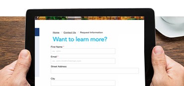 someone holding a tablet with Covenant Learning "Learn More" form displayed